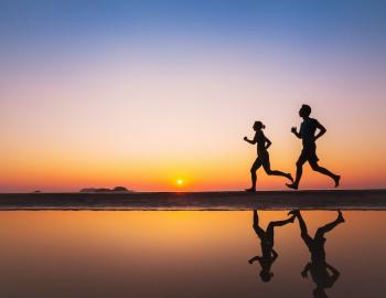 couple enjoying a sunset run on the beach