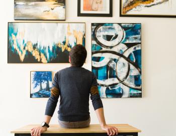 man looking at art on wall in gallery