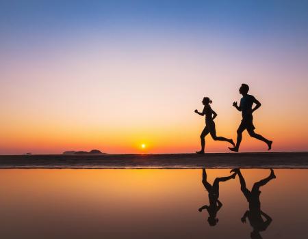 couple enjoying a sunset run on the beach
