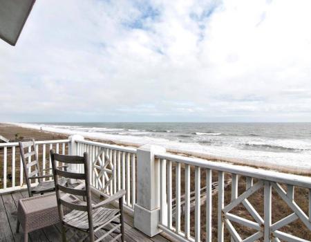 The top balcony of White, a vacation rental home in Carolina Beach, N.C., overlooks the Atlantic Ocean on a mostly cloudy day.