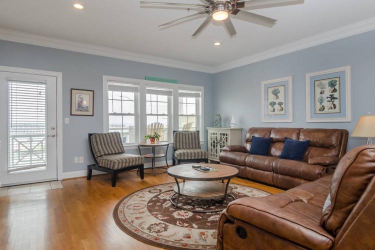 a large living room with natural lighting and leather seating