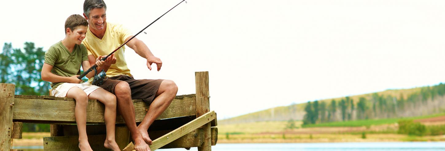 Father and son fishing off a dock