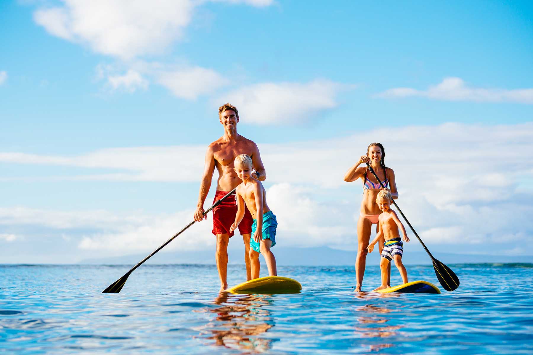 Parents with their kids enjoying stand up paddleboards