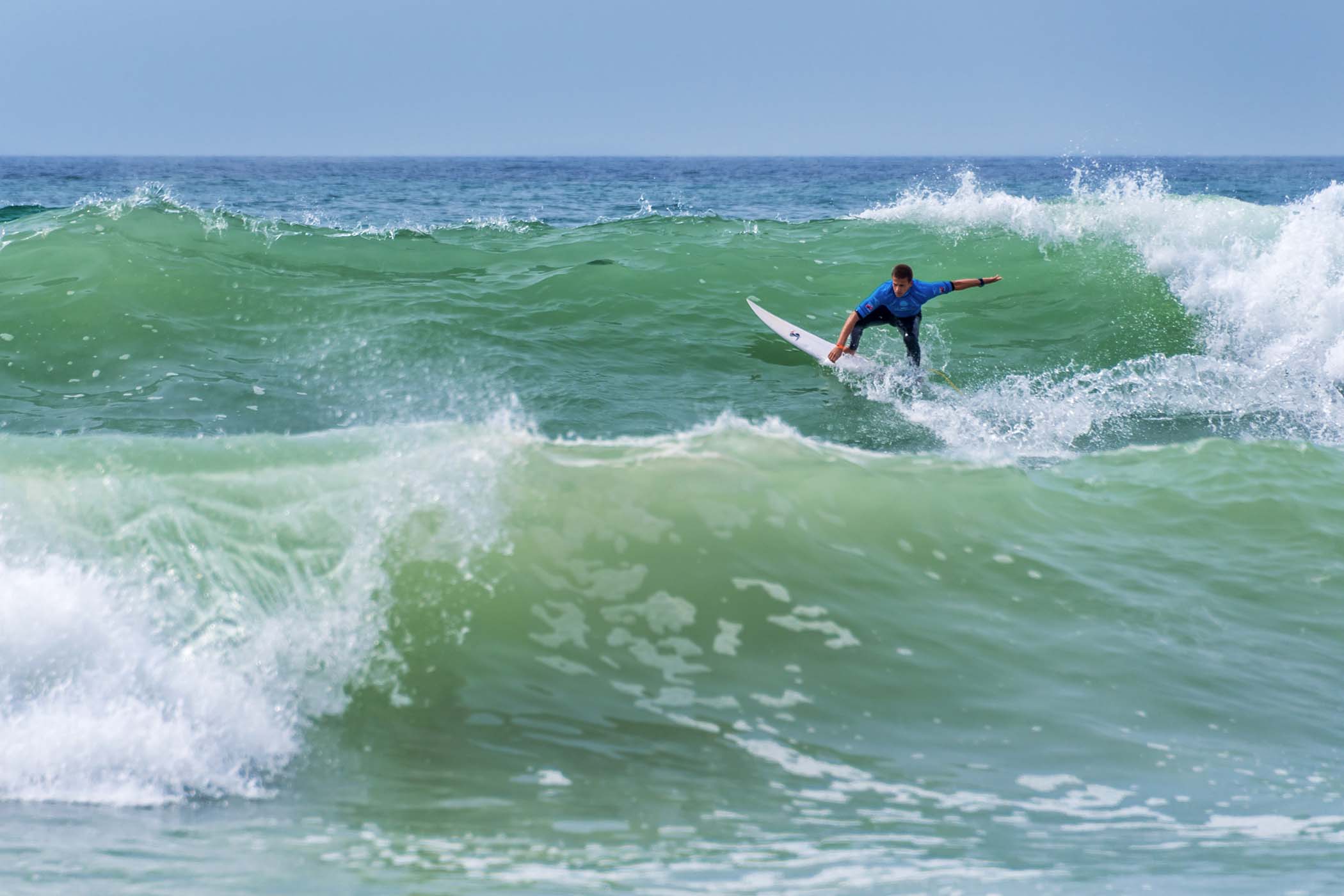 Surfer catching waves on a longboard