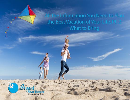 Family flying a kite on a beach vacation.